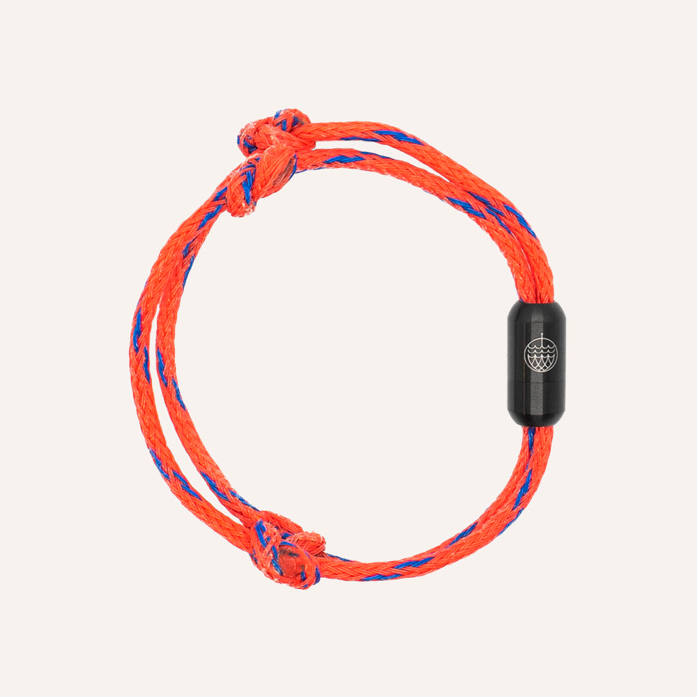 Orange and blue braided bracelet with a black clasp on a white background