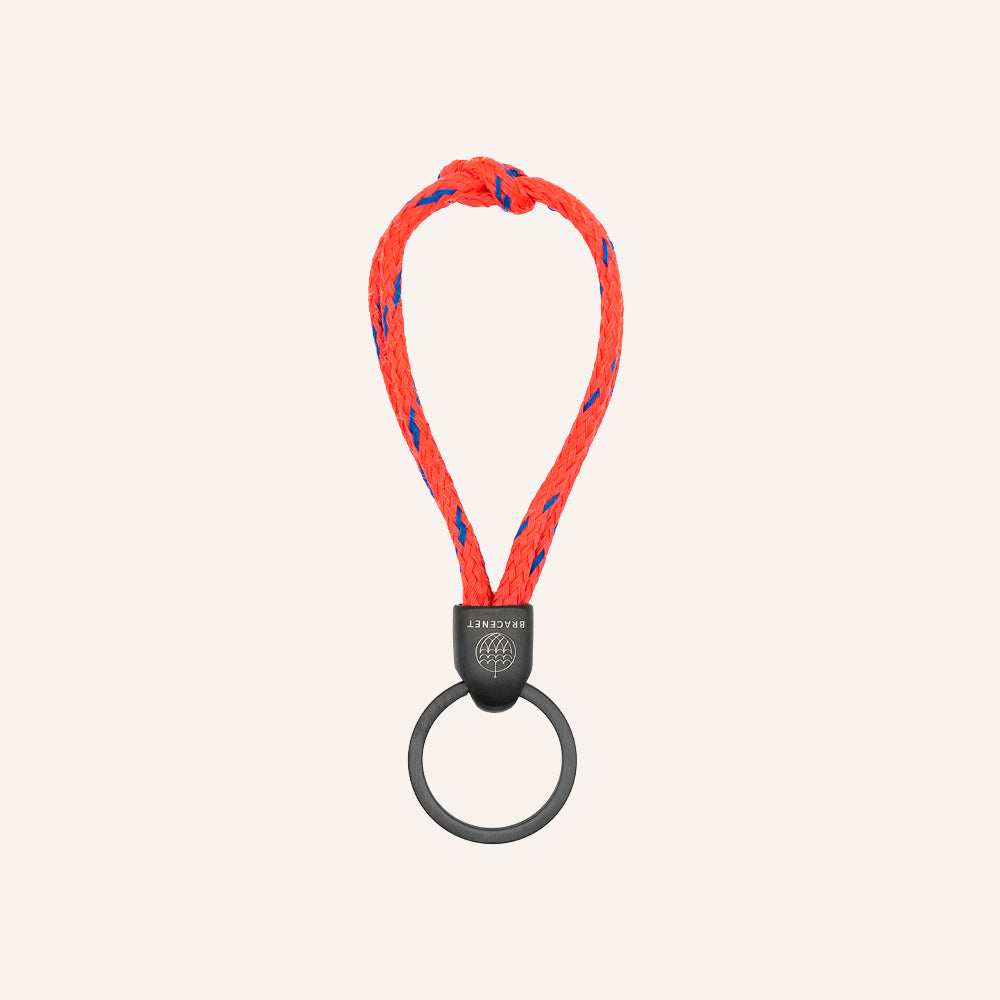 Red and blue braided keychain with a black metal clip on a white background