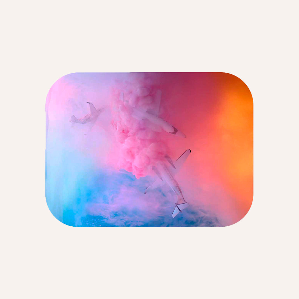 Three airplanes releasing pink smoke against a colorful sky with blue, pink, and orange hues.