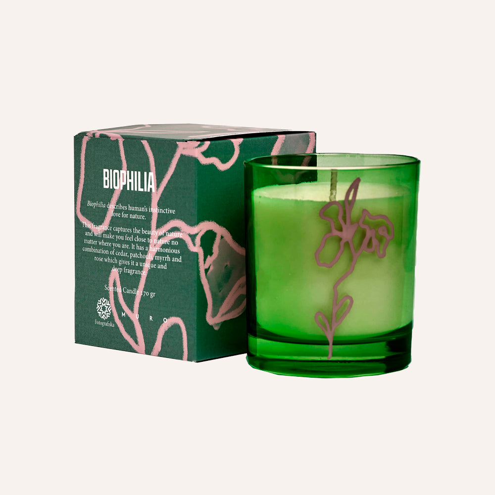 Green candle in a glass holder with a matching green box labeled 'Biophilia'.
