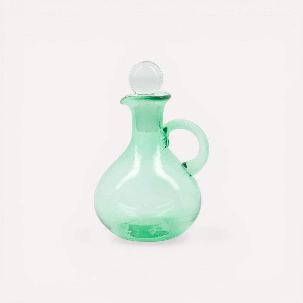 Green glass decanter with a white stopper.