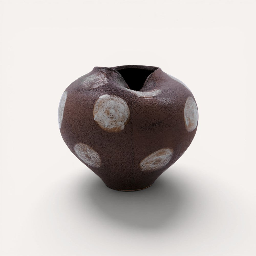 Ceramic vase with brown glaze and white circular patterns.