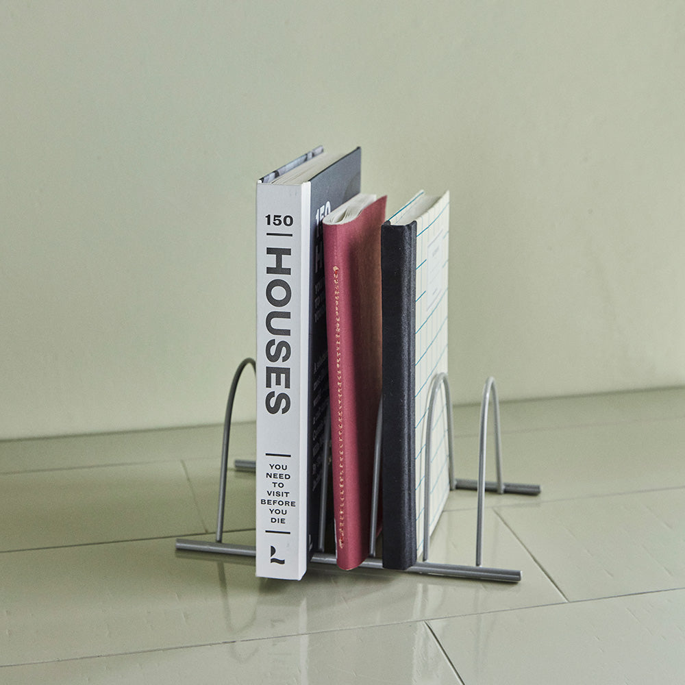 Organiser holding books on a tiled surface with a neutral background