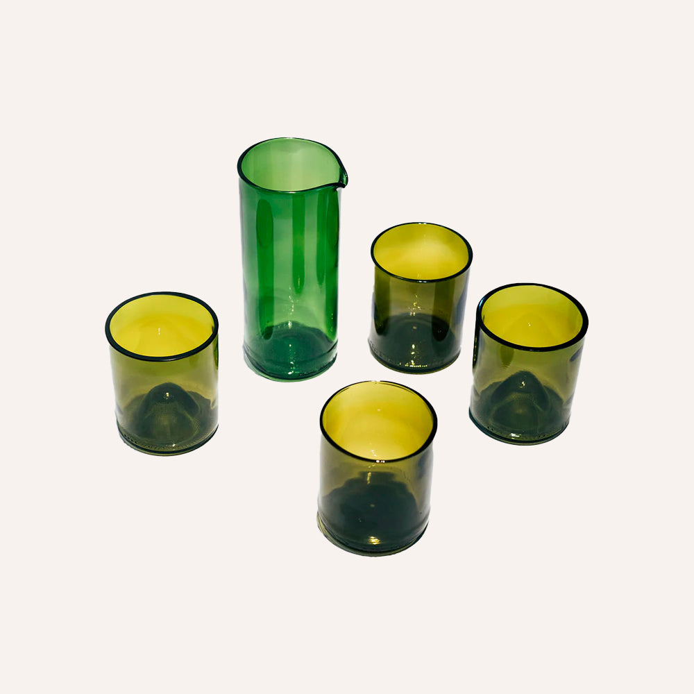 Set of green glass tumblers on a white background