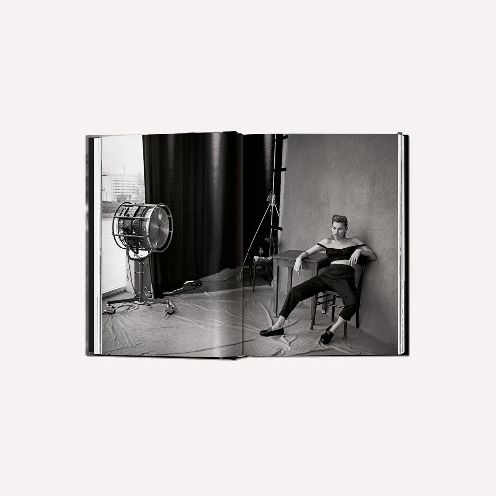 Open book showing a black and white photograph of a person sitting in a studio with a light.