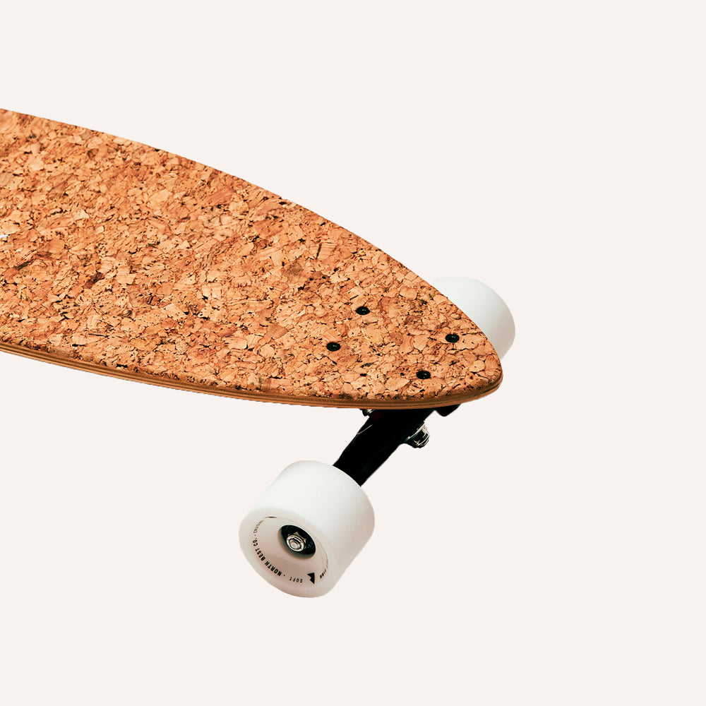 Cork skateboard deck with white wheels on a white background