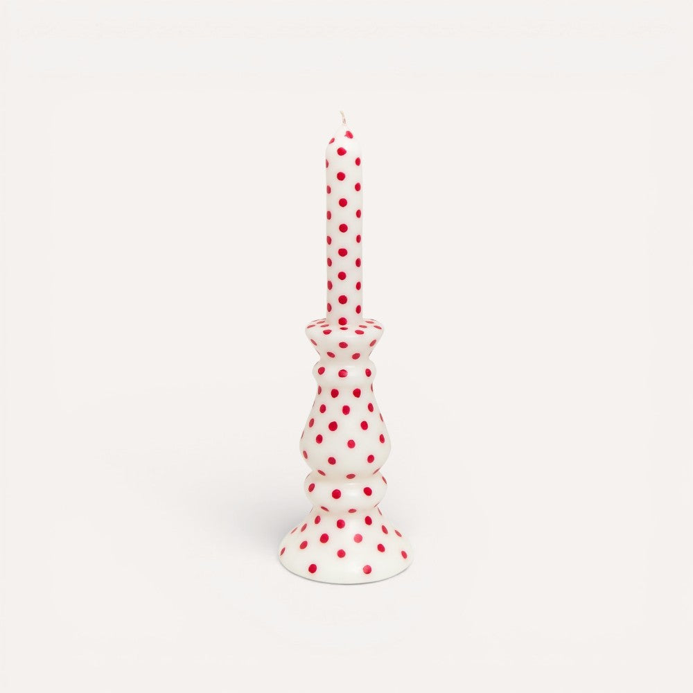 White candle with red polka dots.