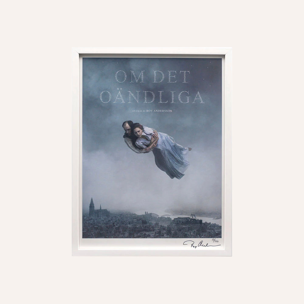 Framed artwork with a woman in a dress floating over a cityscape, titled 'Om Det Oandliga'.