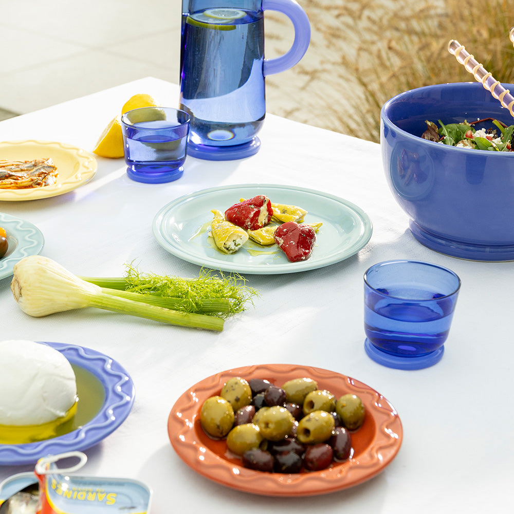 Table setting with plates of food, glasses of water, and a bowl. 