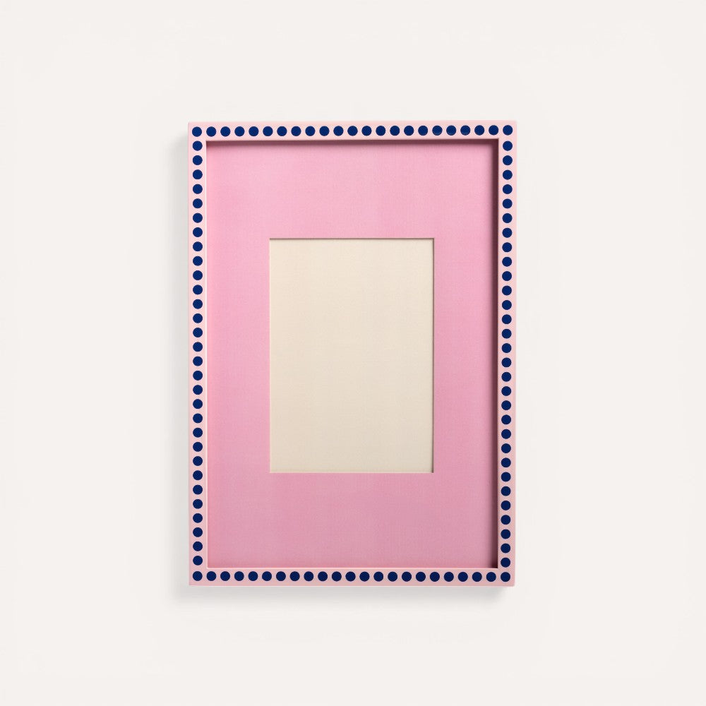 Pink picture frame with blue dots. 