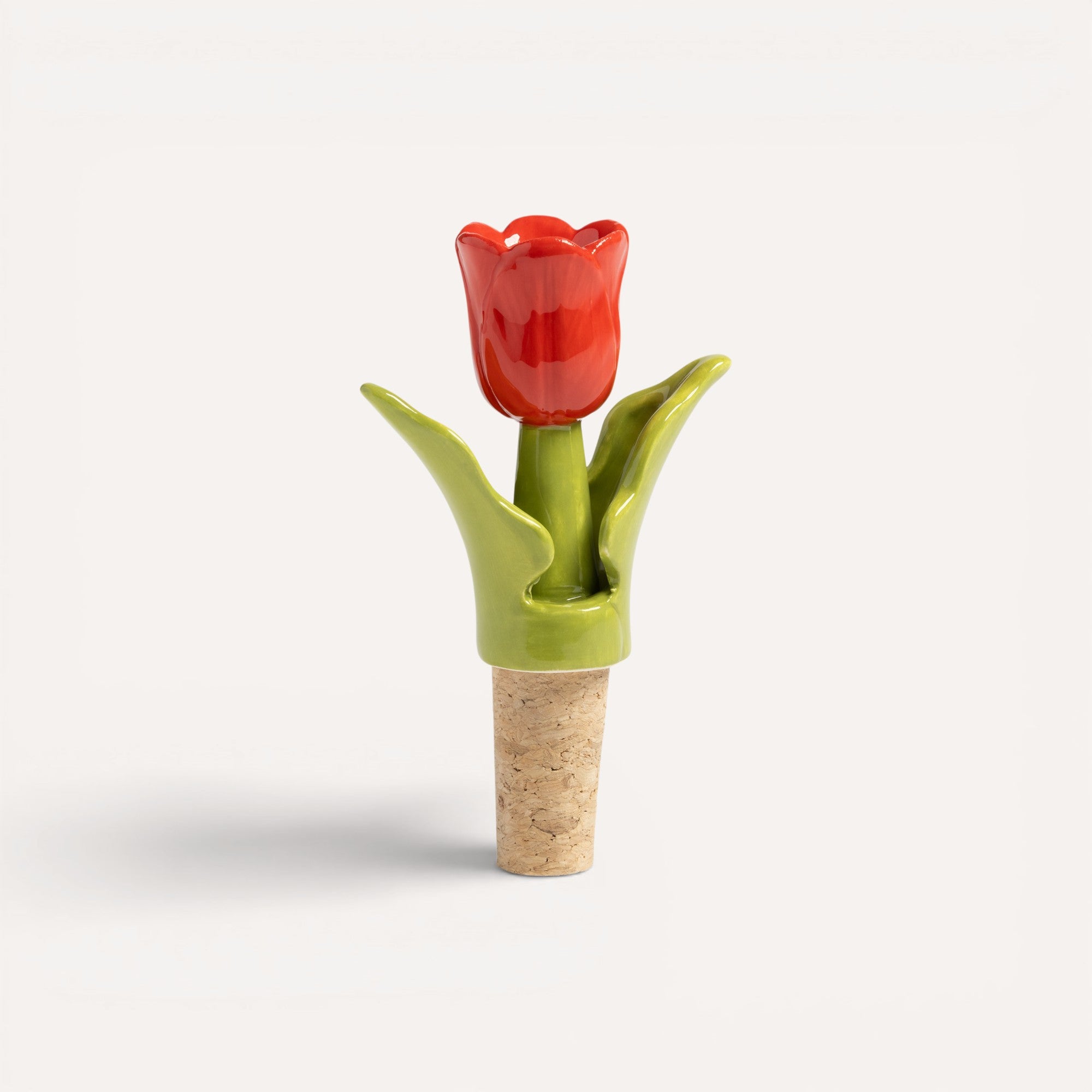 Ceramic tulip-shaped bottle stopper with red flower and green base. 