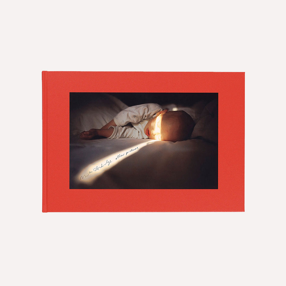 Book cover for Miles Aldridge 'Other pictures', showing a kid lying in bed,  framed by a red border.